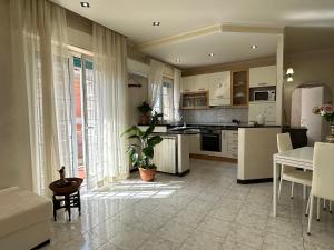 a kitchen with white cabinets and a table and a refrigerator at Casa Liliana in Ladispoli +18 photos
