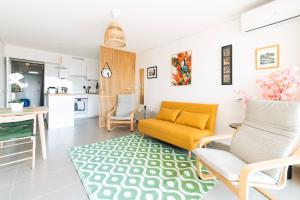 ein Wohnzimmer mit einem orangenen Sofa und einer Küche in der Unterkunft Nouveau T2 Horizon Vue Mer Palavas in Palavas-les-Flots