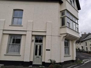 a white house with a white door and windows at Church View House in Drewsteignton