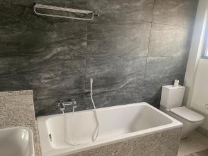 a bathroom with a bath tub and a toilet at PLSA Lovely Three Bedroom Home in Accra +16 photos