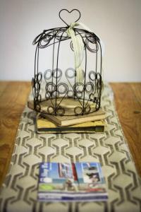 une cage au-dessus de quelques livres sur une table dans l'établissement The Big Tree Cottage, à Graafwater