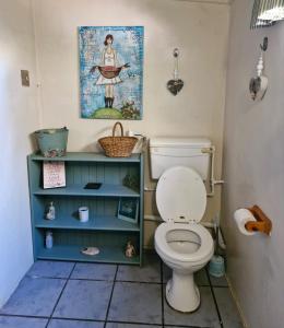 une salle de bain avec toilettes et un tableau au mur dans l'établissement The Big Tree Cottage, à Graafwater