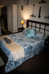 - une chambre avec un lit doté d'une couverture bleue et d'oreillers dans l'établissement The Big Tree Cottage, à Graafwater