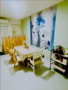 a dining room with a table and chairs and a painting at 簡易宿泊所 櫻花 in Osaka +10 photos