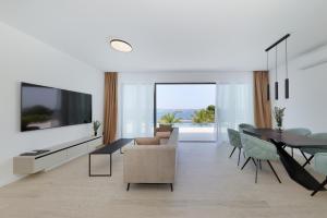 a living room with a television and a table and chairs at Cloud 9 D8 in Tkon