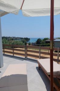 a balcony with a bed and an umbrella at Summer Project Theros in Nea Kalikratia