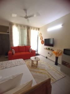 a living room with a red couch and a tv at Smart Homes Kilifi in Kilifi