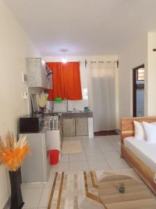 a living room with a bed and a kitchen at Smart Homes Kilifi in Kilifi