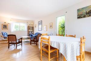 a dining room and living room with a table and chairs at La maison à Landebec in Fouesnant