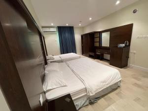 a bedroom with a large bed and a mirror at N Alharbi Serviced apartments in AlUla