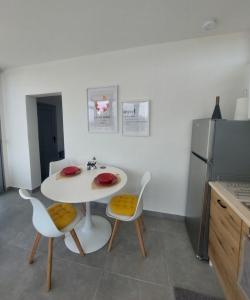 a kitchen with a white table and chairs and a refrigerator at Summer Project Theros in Nea Kalikratia