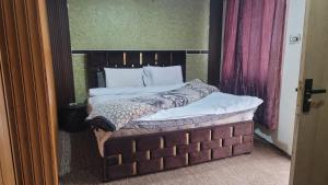 Un dormitorio con una cama grande con cabecero de madera. en Pleasant View Murree, en Murree
