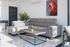 ein Wohnzimmer mit einer Couch und einem Tisch in der Unterkunft HiddenGems Residences 202 - The LXR Penthouse - Pool & Beach Steps in Paphos City