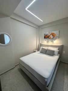 a bedroom with a large white bed with a window at Villa Agora in Nikiti