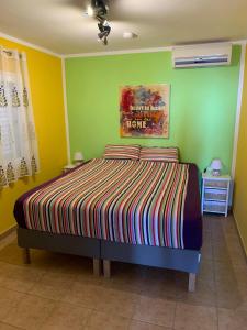 ein Schlafzimmer mit einem Bett und einem Gemälde an der Wand in der Unterkunft Großzügige Ferienwohnung mit Atlantikblick in zentraler Lage Monte Rojo San Agustín in San Bartolomé de Tirajana