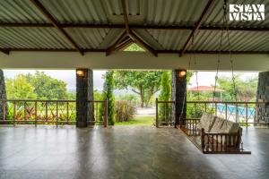 a room with a porch with a swing at StayVista at Bayleaf Villa with Pool, Lawn, Wi-Fi in Nashik