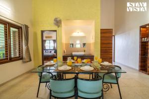 a dining room with a glass table and chairs at StayVista at Bayleaf Villa with Pool, Lawn, Wi-Fi in Nashik +23 photos
