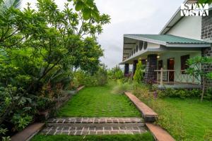 a garden in front of a house at StayVista at Bayleaf Villa with Pool, Lawn, Wi-Fi in Nashik