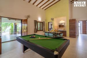 a billiard room with a pool table in a house at StayVista at Bayleaf Villa with Pool, Lawn, Wi-Fi in Nashik