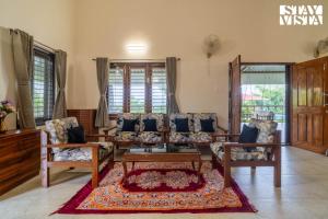 a living room with a couch and two chairs at StayVista at Bayleaf Villa with Pool, Lawn, Wi-Fi in Nashik