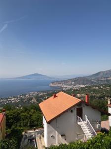 a white house with a red roof and the water at Villa Walter in Sorrento