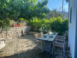 une table et des chaises assises sur une terrasse dans l'établissement Ληγάτο Cottage House, à Áyios Pétros 26 autres photos