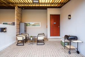 Zimmer mit Stühlen, einem Tisch und einer Tür in der Unterkunft The Ville Jomtien Pool Villa in Jomtien Beach