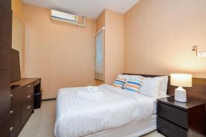 ein Schlafzimmer mit einem Bett, einer Kommode und einem Fernseher in der Unterkunft The Ville Jomtien Pool Villa in Jomtien Beach