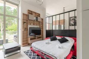 ein Schlafzimmer mit großem Bett und Fernseher in der Unterkunft L'Albissia - 100m mer - Parking - Wifi in Pornic