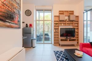 ein Wohnzimmer mit einem Kühlschrank und einem TV in der Unterkunft L'Albissia - 100m mer - Parking - Wifi in Pornic