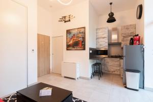 eine Küche mit einem Kühlschrank und einem Tisch in der Unterkunft L'Albissia - 100m mer - Parking - Wifi in Pornic