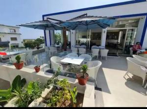a patio with a table and chairs and umbrellas at Grand appartement avec piscines in Cabo Negro
