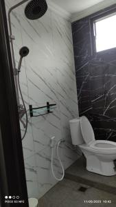 a bathroom with a shower and a toilet in it at Titik Senja Vila Dieng in Dieng