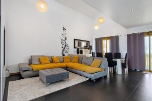 una sala de estar con un sofá y una mesa en Casa da Orquidea, en Ribeira Grande