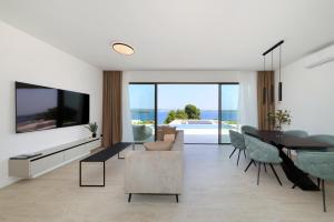 a living room with a television and a table and chairs at Cloud 9 D9 in Tkon