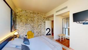 a bedroom with a bed and a tv on the wall at Arcs De Monells - Adults Only in Monells