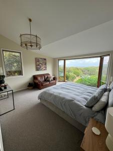 a bedroom with a large bed and a large window at Ocean View Farm in Red Hill South