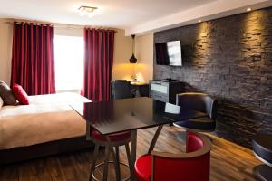 a hotel room with a bed and a desk at Hôtel Saint-Germain Rimouski in Rimouski +42 photos
