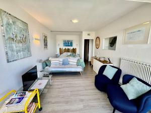 un salon avec des chaises bleues et un canapé dans l'établissement Appartement 2 Pers. à 50m Plages avec WIFI et Parking - FR-1-368-275, à Trégastel