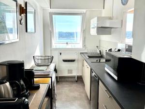 une petite cuisine avec un évier et une fenêtre dans l'établissement Appartement 2 Pers. à 50m Plages avec WIFI et Parking - FR-1-368-275, à Trégastel
