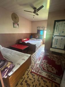 a bedroom with two beds and a couch in it at Darshan Namaste Restaurant and Cocktail Bar in Meghauli