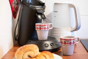 une cafetière avec deux tasses à café et des bretzels dans l'établissement Duplex 3 châteaux, à Eguisheim