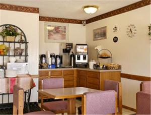 eine Küche mit einem Tisch, einem Tisch und Stühlen in der Unterkunft Super 8 by Wyndham Evansville East in Evansville