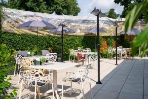 a patio with tables and chairs with umbrellas at NOVALIS Hotel Dresden by AURUM in Dresden