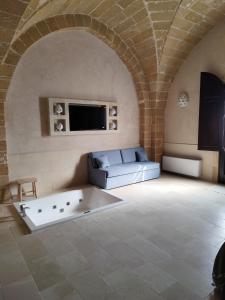 a living room with a couch and a tv at Borgo Don Ciccio in Felline