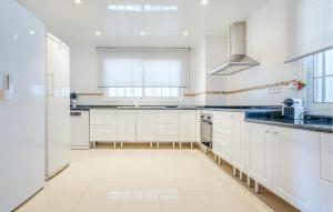 セグル・デ・カラフェルにあるLovely Home In Segur De Calafellの白いキャビネットと青いカウンタートップが備わる白いキッチン