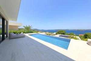 a villa with a swimming pool in front of a house at Cloud 9 D9 in Tkon