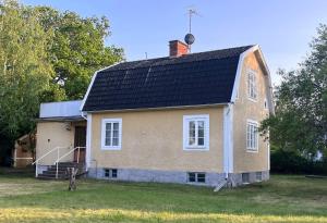 ein Haus mit schwarzem Dach auf einem Hof in der Unterkunft KalmarStay in Ålem
