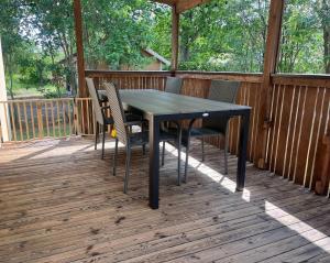 Ein schwarzer Tisch und Stühle auf einer Holzterrasse in der Unterkunft KalmarStay in Ålem