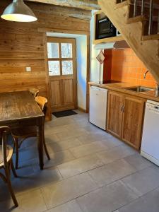 a kitchen with wooden cabinets and a table in a cabin at Au Vialaou - Chez Marcelle in Névache